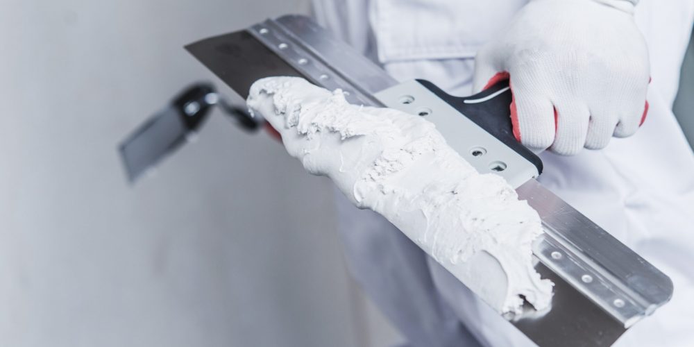Preparing For Drywall Patch. Patching Tools in Hand of Worker Closeup Photo